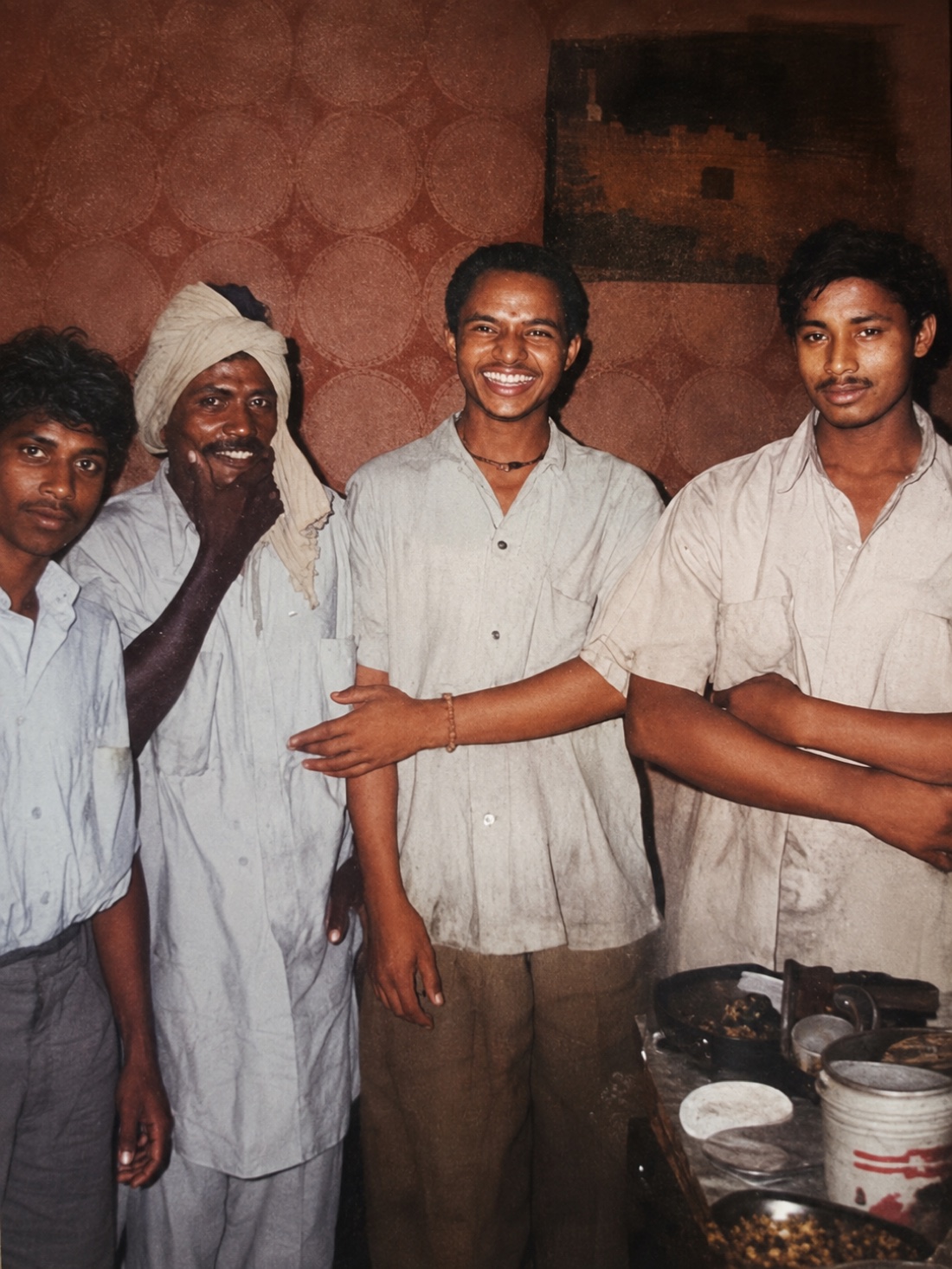 Four people smiling together in an early restaurant photograph